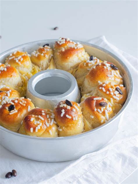 Immagine di brioche soffici appena sfornate, con un leggero velo di zucchero a velo o granella di zucchero.