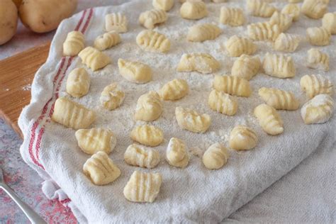 Gnocchi crudi disposti su un vassoio per il congelamento