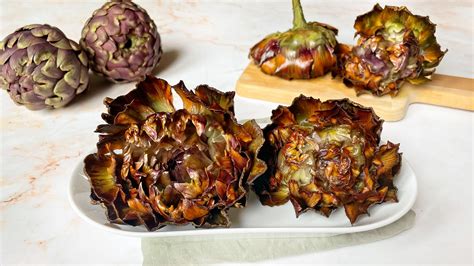 carciofi alla giudia disposti a forma di fiore dorato su un piatto