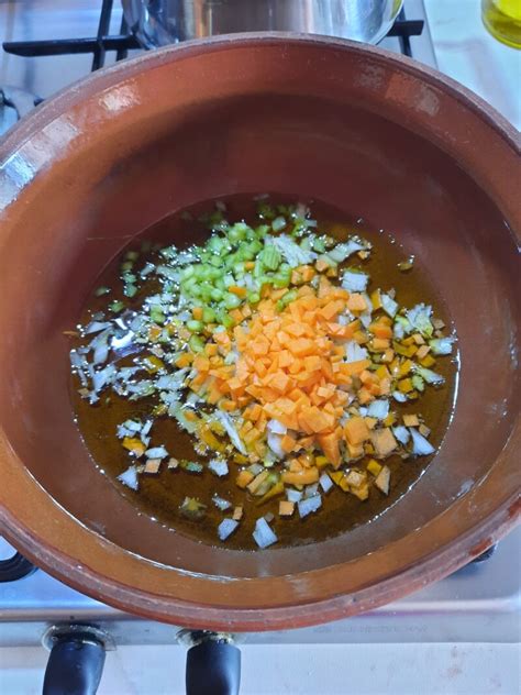 Soffritto di verdure e pancetta in un tegame di terracotta