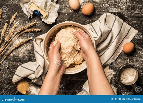 Primo piano delle mani che impastano la focaccia in una ciotola, con ingredienti visibili come farina, latte e lievito.
