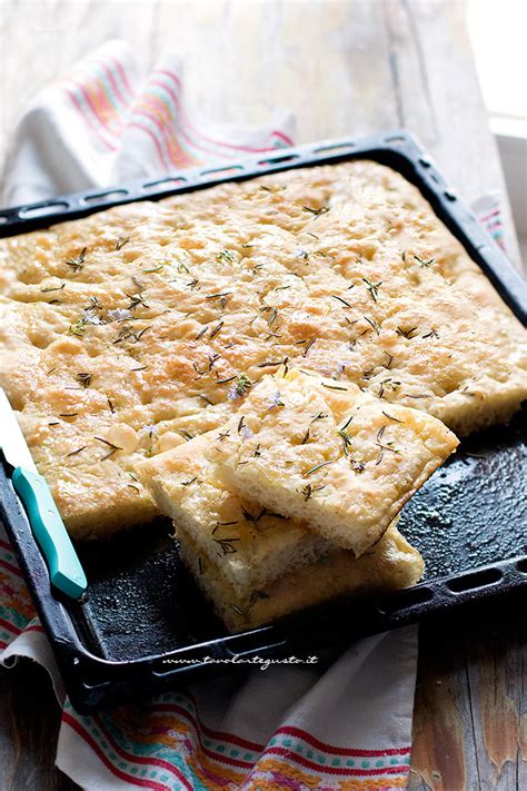 Una focaccia morbida tagliata a spicchi e farcita con mortadella, pronta per essere servita.