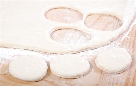 Dischi di impasto per focaccine disposti su una teglia, pronti per la lievitazione.