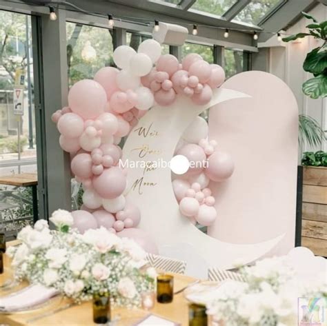 Angolo photo booth decorato con palloncini rosa pastello, festoni e accessori a tema giostra