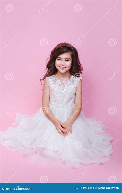Bambina vestita da principessa che decora cupcake rosa