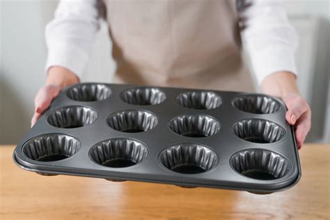 Diverse forme e dimensioni di stampi in silicone per dolci, disposti su uno sfondo chiaro