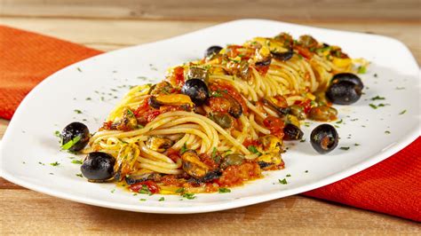 Spaghetti che assorbono il sugo nella padella, con aggiunta di acqua di cottura