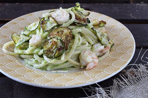 Piatto finito di pasta con zucchine, gamberetti e rucola, impiattato con un ciuffo di prezzemolo fresco