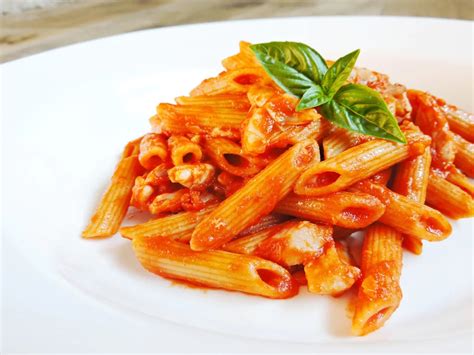Ingredienti freschi per la pasta al pomodoro gratinata: pomodori maturi, formaggio, basilico.