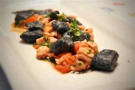 Formazione manuale di gnocchi al nero di seppia con rigatura su forchetta