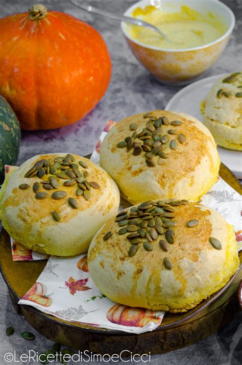 Panini alla zucca dorati e decorati, disposti su un piatto da portata