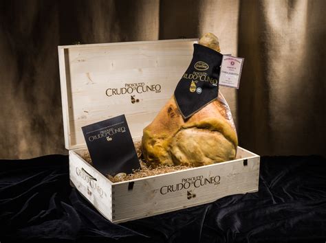 Tavola apparecchiata con Prosciutto Crudo di Cuneo DOP, formaggi locali e un calice di vino