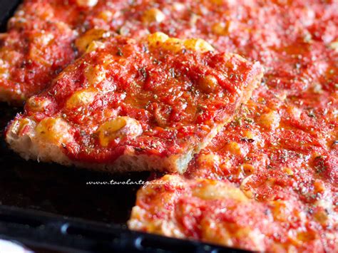 pizza scrocchiarella rossa condita e pronta per essere infornata
