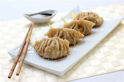 Una selezione di Gyoza, ravioli giapponesi dorati e croccanti, pronti per essere gustati come antipasto o contorno.