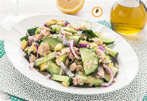 Un piatto di tonno cotto in tempura, dorato e croccante, servito con avocado fresco, cetrioli e alghe wakame, mostrando un contrasto di colori e texture.