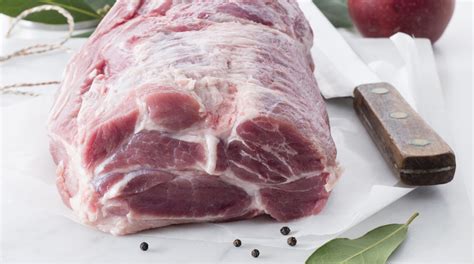 Una coppa di maiale intera, appena tolta dalla griglia, avvolta in carta argentata per il riposo.