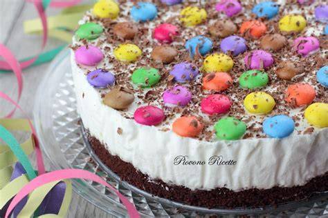 Primo piano di una cheesecake decorata con Smarties colorati.