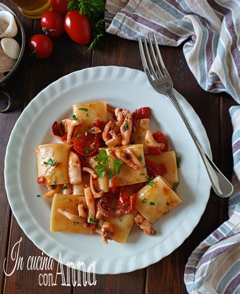 Primo piano dei calamari saltati con pomodorini in padella
