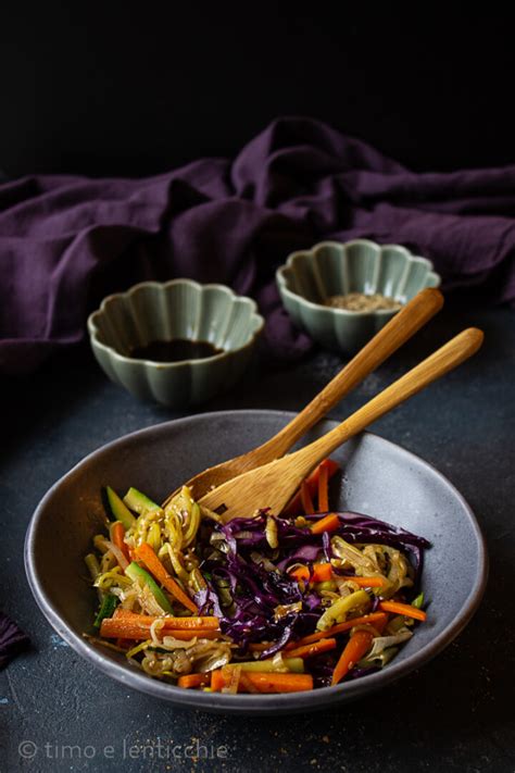 Wok con verdure saltate a fiamma viva: carote, cipolla, cavolo cappuccio che saltano nel wok.