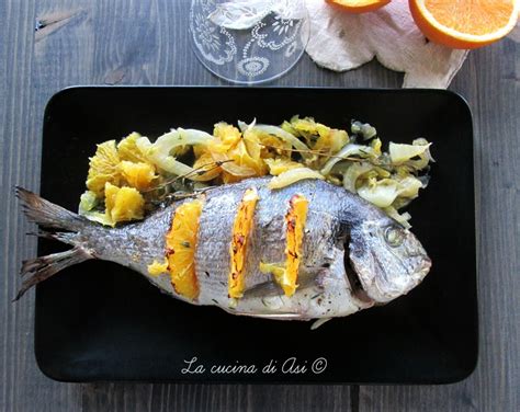 Orata al forno con fette di arancia e finocchio disposte intorno e sopra il pesce
