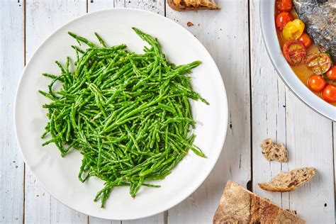 Primo piano di salicornia lessata e condita con olio e limone, pronta per essere servita.
