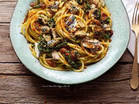 Impiattamento di pasta con le sarde, guarnita con foglie di finocchietto fresco.