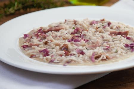 Ingredienti per il risotto radicchio e pancetta, disposti in modo ordinato su un piano di lavoro.