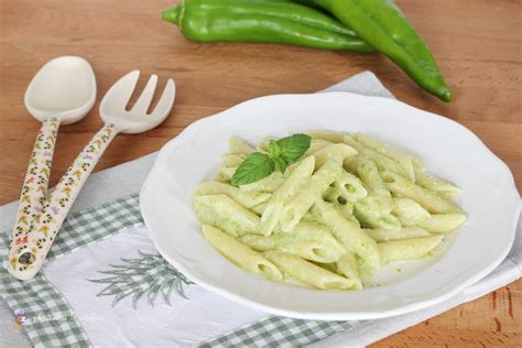 un piatto di crema di peperoni verdi servita con spiedini di sardina e guarnizione di peperoni e mandorle