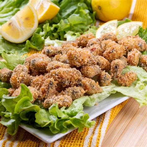 Immagine di cozze fritte servite su una delicata mousse di carciofi in ciotoline monoporzione.