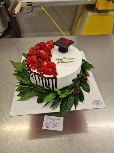 Illustrazione di una torta di laurea decorata con un tocco e una pergamena.