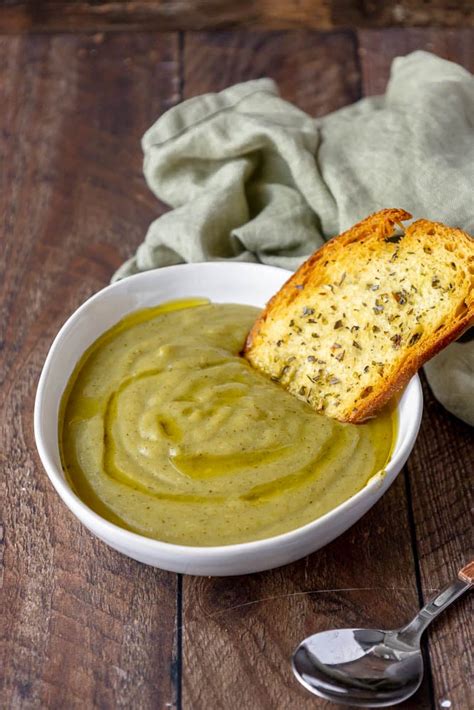 La crema di broccoli servita in ciotole individuali, guarnita con guanciale croccante e crostini di pane.