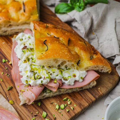 Foto di una michetta farcita con mortadella, burrata e pesto di pistacchio