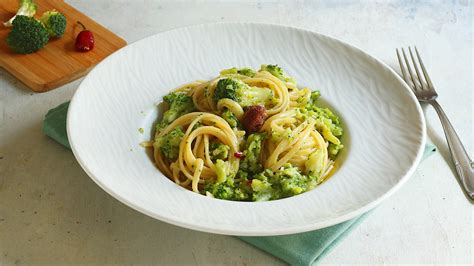 Primo piano di un piatto di pasta con broccoli, condita con acciughe e peperoncino