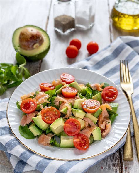 Composizione di un'insalata estiva con salmone affumicato, avocado e verdure fresche.