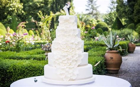 illustrazione storica di una torta nuziale a più piani con figure stilizzate di sposi in cima