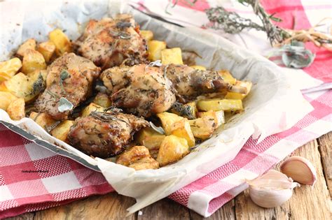 Coniglio con patate e olive disposto nella pirofila prima della cottura