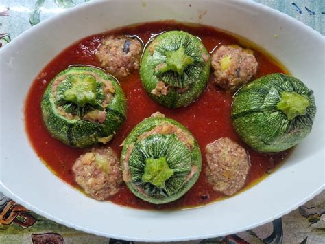 Primo piano di zucchine tonde ripiene pronte per essere servite, con un ripieno visibilmente appetitoso.