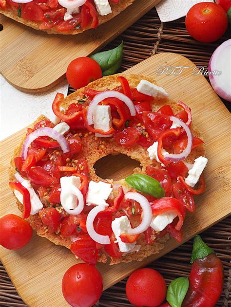 primo piano di friselle condite con pomodorini, basilico e un filo d'olio