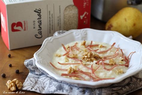Piatto finito di risotto con pere, speck e brie, decorato con pere essiccate e polvere di speck