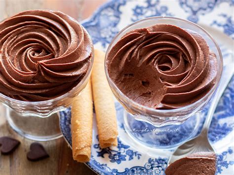 Immagine di una mousse al cioccolato in una coppetta, guarnita con panna e cacao