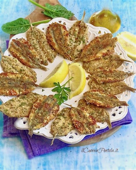 Piatto di alici al forno dorate e croccanti, servite con contorno