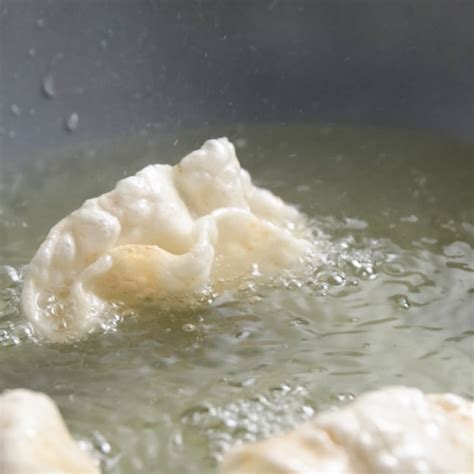 Fettine sottili di impasto per nuvole di drago disposte su teglia da forno