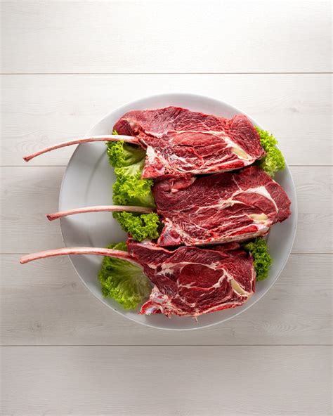 Illustrazione schematica del taglio Tomahawk, evidenziando l'osso lungo e la marmorizzazione della carne.