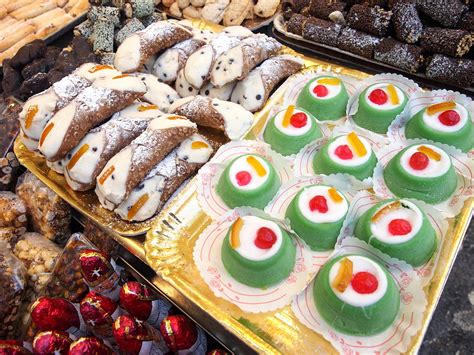 Un assortimento di dolci siciliani, tra cui cannoli, cassata e paste di mandorla.