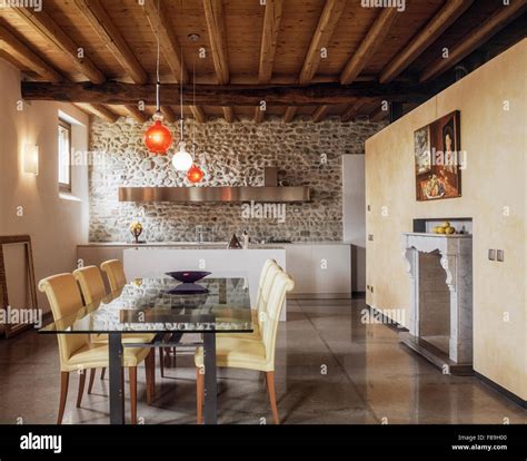 Interno di una sala da pranzo con camino e cucina in muratura