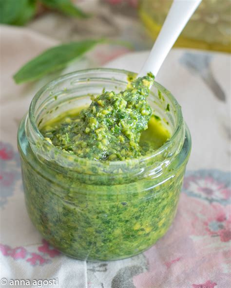 Immagine ravvicinata di pistacchi tostati e ingredienti per il pesto, come basilico e olio.