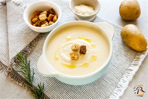 Immagine di una ciotola di crema di patate allo zafferano, guarnita con crostini di pane e un filo d'olio d'oliva.