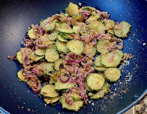 padella con zucchine, cipolla e pomodoro in cottura
