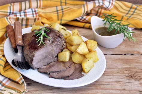 fette sottili di roast beef su un piatto con contorno di patate arrosto
