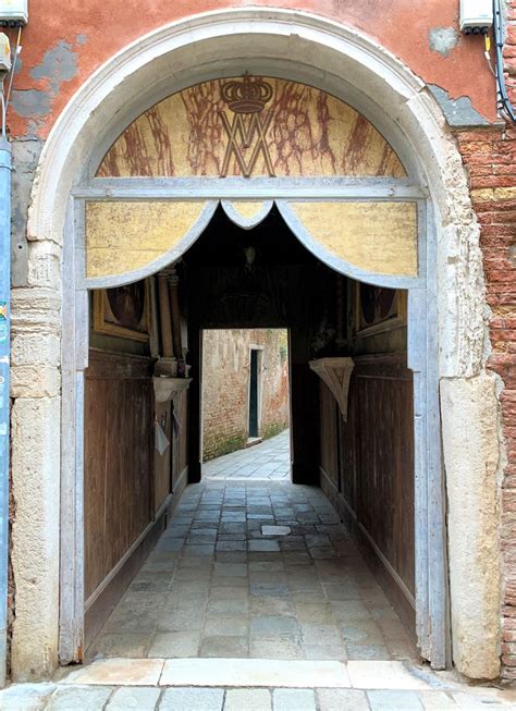 scorcio di un sottoportego veneziano con una pietra rossa visibile
